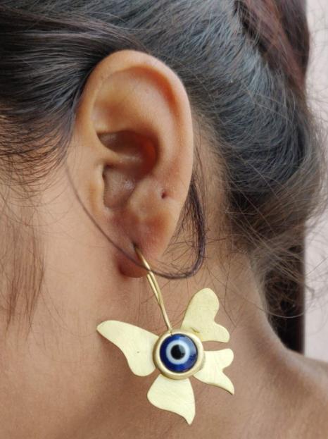 Evil eye stone with butterfly shaped brass earrings in Germany